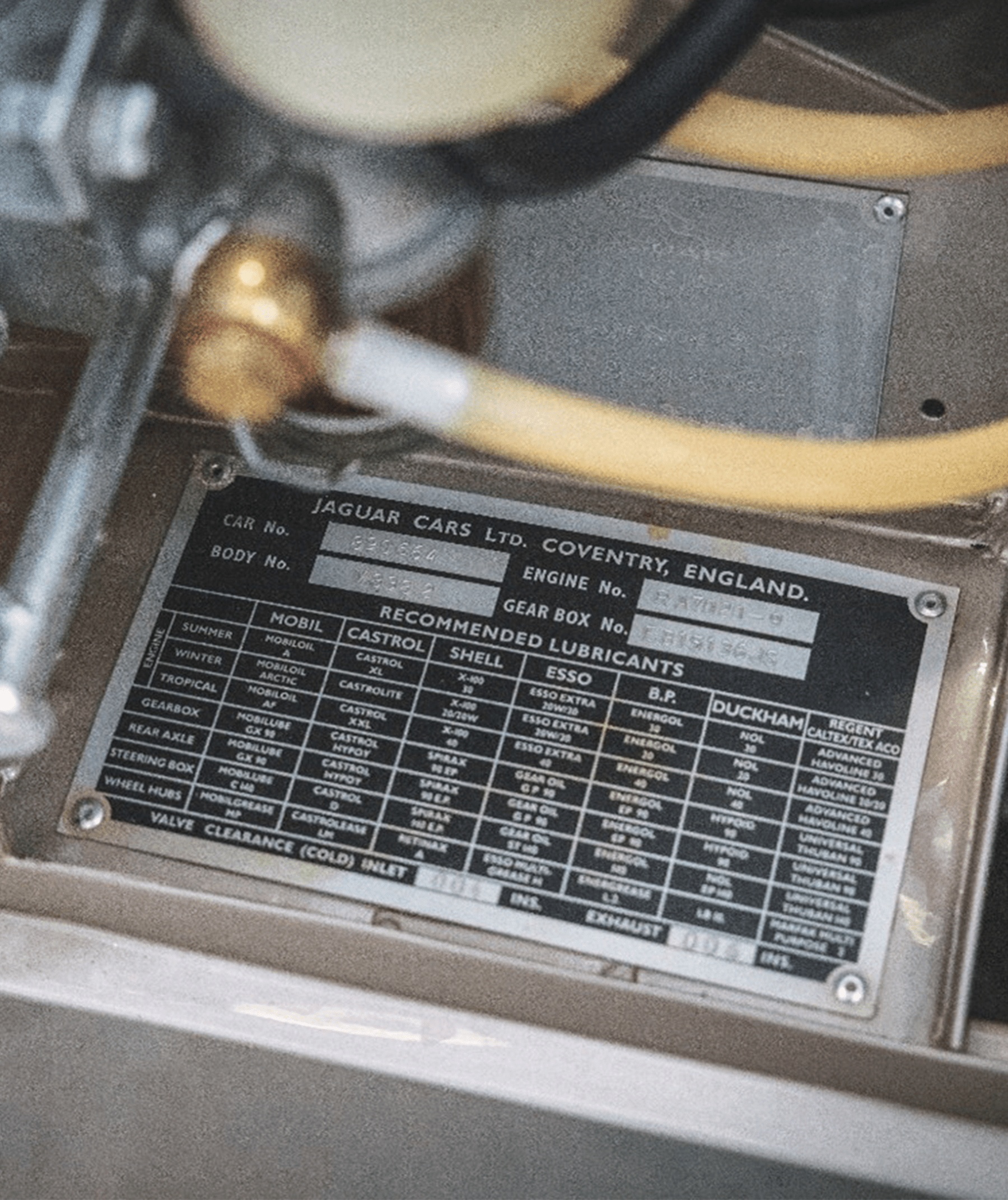 Jaguar metal plate listing car details and recommended lubricants.