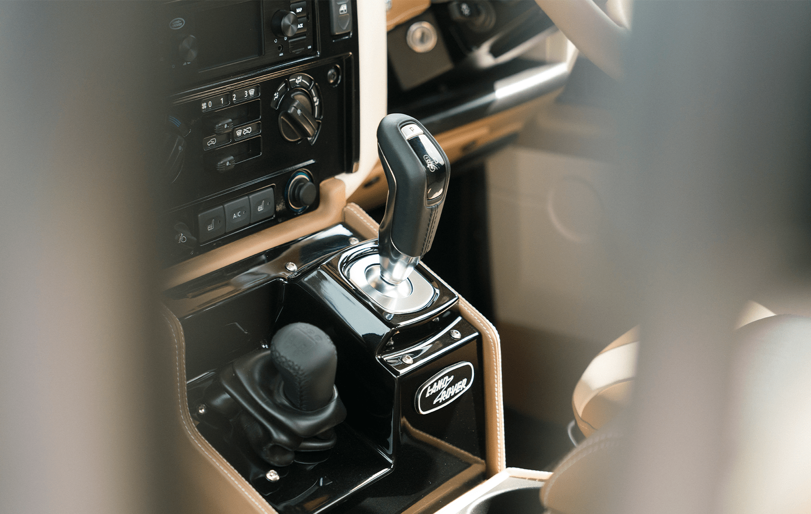 Interior view of a Land Rover centre console with gear shift and control knobs.