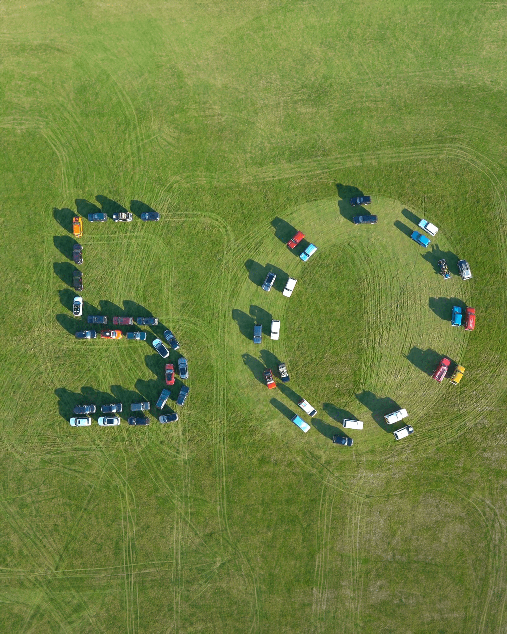 Range Rovers arranged on grass to form number '50'.